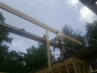 Carpenter setting a ridge beam over a new addition frame — Ice Dam Removal by Roofing Brothers in Forest Ranch