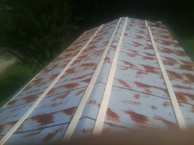 Rusted metal roof panels with new wood purlins before replacement — Storm Damage Roof Repair in Forest Ranch by Roofing Brothers