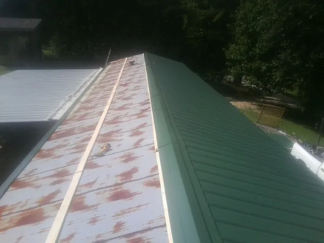 Old rusted panels beside newly installed green metal roofing — Wind Damage Roof Repair by Roofing Brothers in Forest Ranch